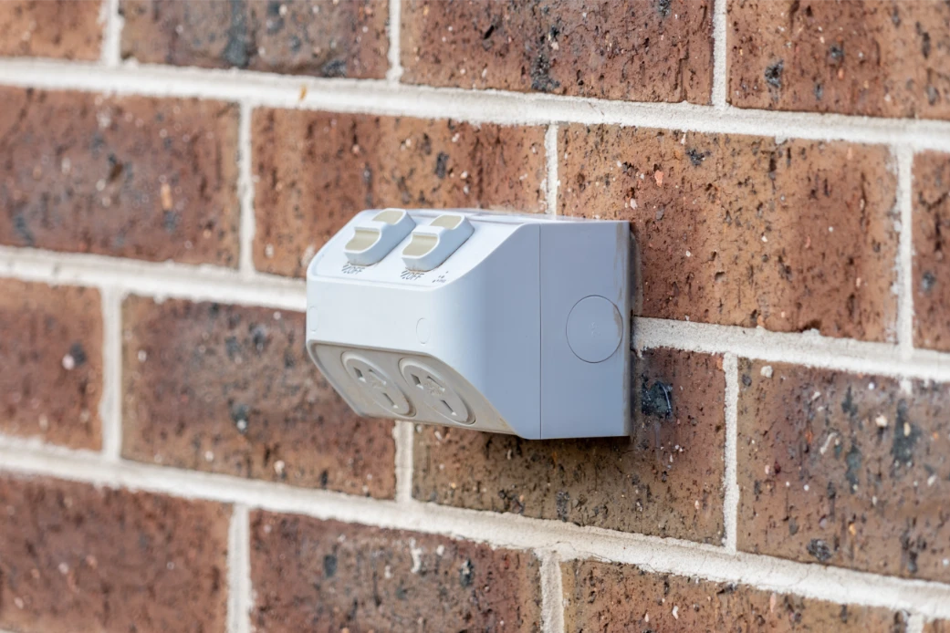 Weatherproof outdoor power point installed on brick wall